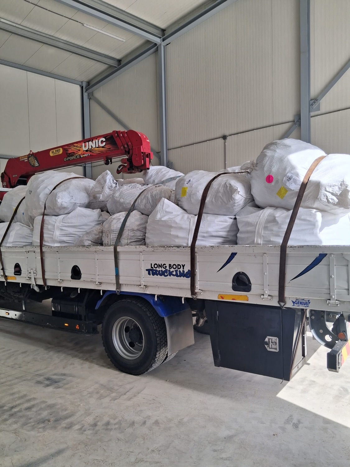 Vrachtwagen vol bigbags in de loods